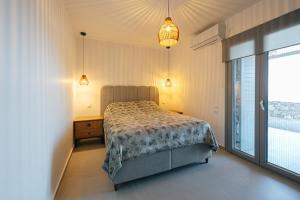 a bedroom with a bed and a large window at Vigla View Sifnos in Vathi