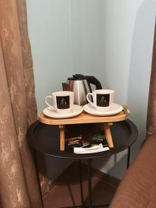 two coffee cups and a tea kettle on a table at Hotel Jacob in Ureki