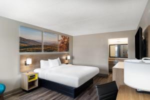 a hotel room with a bed and a desk at Days Inn by Wyndham Greeneville in Greeneville