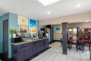 a kitchen with blue cabinets and a bar with a table at Days Inn by Wyndham Greeneville in Greeneville