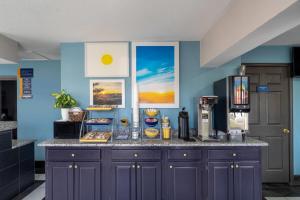a kitchen with blue walls and a counter with food at Days Inn by Wyndham Greeneville in Greeneville +19 photos