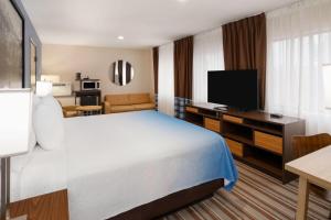 a hotel room with a bed and a television at Super 8 by Wyndham Longmont/Twin Peaks in Longmont +18 photos