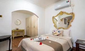 a bedroom with a bed with a large mirror at Le Bonheur Villa in Victoria +95 photos