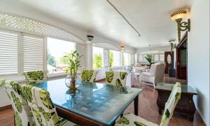a dining room with a glass table and chairs at Le Bonheur Villa in Victoria