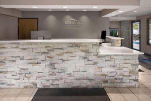 a stone counter in a lobby with a stone wall at Baymont by Wyndham Logan in Logan +25 photos