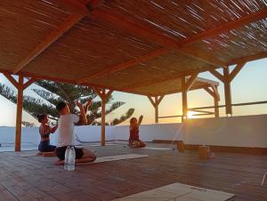 a group of people doing yoga on the beach at Infinity Wellness Sea View Suites in Afráta