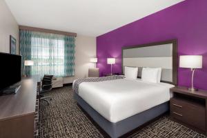 a hotel room with a large bed and a purple wall at La Quinta by Wyndham Springfield IL in Springfield +49 photos