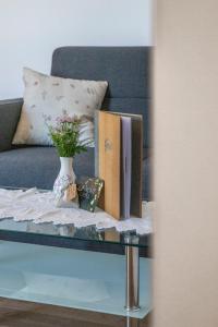 a table with books and a vase on a couch at Weingut Peter Grill in Leutschach