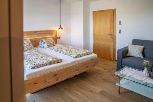 a bedroom with a bed and a couch and a table at Weingut Peter Grill in Leutschach