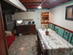 a room with a table and a tv in a room at Pensión San Andrés in Concepción