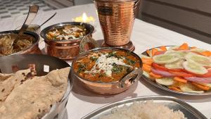 a table with bowls of food on a table at Hotel Dev Darshan in Uttarkāshi