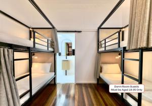 ein Zimmer mit zwei Etagenbetten und einem Flur in der Unterkunft Hervey's in Hervey Bay