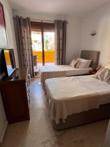 a hotel room with two beds and a television at Spacious ground floor apartment in Punta Prima +35 photos