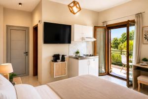 ein Schlafzimmer mit einem Bett und einem Fernseher an der Wand in der Unterkunft Artemida Pansion Georgioupolis in Kournás