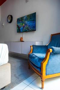 a living room with a blue couch and a tv at Nziwa's Paradise Bamburi in Mombasa