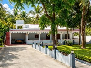 a white house with palm trees in front of it at DNN Brothers Villa in Jaffna