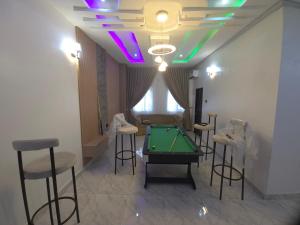 a room with a pool table and some bar stools at House 27 Cool vibes in Idu