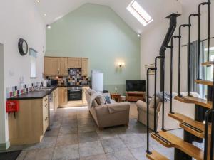 a kitchen and living room with a couch and a table at No 1 The Granary in Llangefni