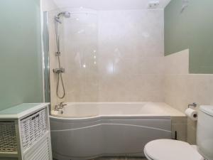 a bathroom with a bath tub and a toilet at No 1 The Granary in Llangefni +20 photos