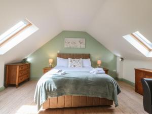 a bedroom with a large bed with two skylights at No 1 The Granary in Llangefni