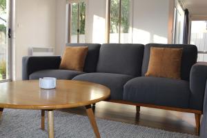 a living room with a blue couch and a coffee table at Sunbury on the Park in Sunbury