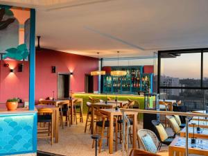 a restaurant with tables and chairs and a bar at ibis Styles - Nairobi, Westlands in Nairobi