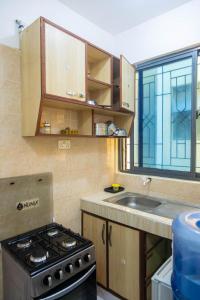 a kitchen with a stove and a sink and a window at Nziwa's Paradise Bamburi in Mombasa