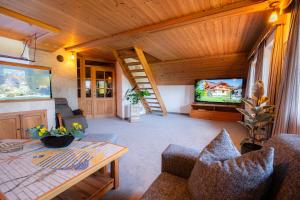 a living room with a table and a tv at Penzion Berc in Bled