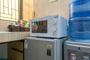 a microwave sitting on top of a refrigerator at Nziwa's Paradise Bamburi in Mombasa +5 photos