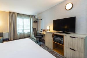 a hotel room with a bed and a flat screen tv at Comfort Inn Saskatoon Centre in Saskatoon