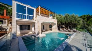 a house with a swimming pool in front of a house at Villa Toma by Villas Guide in Orebić