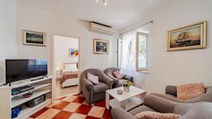 a living room with two chairs and a flat screen tv at Villa Toma by Villas Guide in Orebić