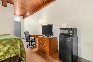 a hotel room with a bed and a microwave and a television at Econo Lodge Tallahassee Downtown - University in Tallahassee