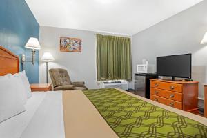 a hotel room with a bed and a flat screen tv at Econo Lodge Tallahassee Downtown - University in Tallahassee