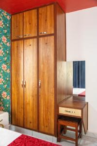 a bedroom with a wooden cabinet and a desk at Nziwa's Paradise Bamburi in Mombasa