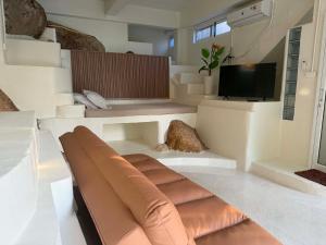 a living room with a couch and a tv at Khao Raa Terrace @Phangan in Ban Madua Wan