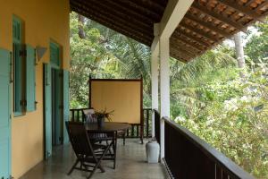 a porch with a table and chairs on it at The Last House in Tangalle