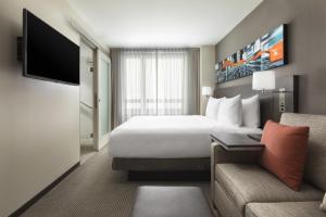 a hotel room with a bed and a couch at Hyatt Place New York City - Times Square in New York