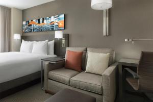 a hotel room with a bed and a couch at Hyatt Place New York City - Times Square in New York +24 photos