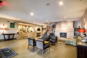 a living room with a fireplace and some chairs at Country Inn & Suites by Radisson, Fond du Lac, WI in Fond du Lac