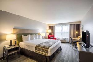 a hotel room with a large bed and a desk at Country Inn & Suites by Radisson, Fond du Lac, WI in Fond du Lac +77 photos