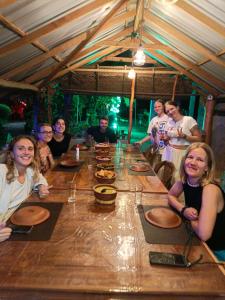 a group of people sitting around a large wooden table at Sigiri Lake Paradise in Sigiriya