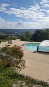 a swimming pool with a car parked next to it at Les Gîtes de l'aiguete in Hauterives