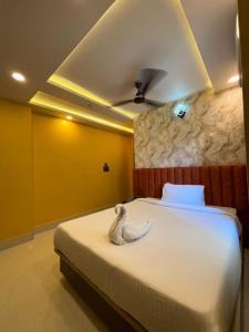 a bedroom with a bed with a swan on it at Hotel Mukti Residency in Mātigara