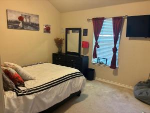 a bedroom with a bed and a mirror and a window at Trunks up! Spacious home ready for a fun time! in Lancaster
