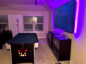 a room with a pool table and a flat screen tv at Trunks up! Spacious home ready for a fun time! in Lancaster +3 photos