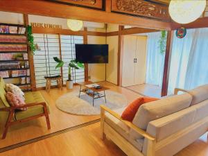 a living room with a couch and a tv at Nagoya kiyosu温もりの宿貸切一軒家駅近3分 in Nishi-biwajima
