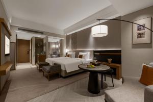 a hotel room with a bed and a living room at Rainbird Hotel in Chengdu