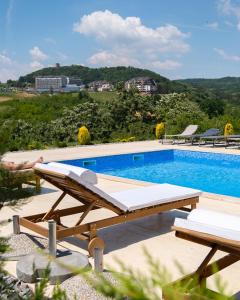 a swimming pool with a bench next to a table at Green panorama Vrdnik in Vrdnik