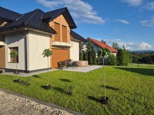 a house with two palm trees in the yard at Apartament Królówka in Nowy Wiśnicz